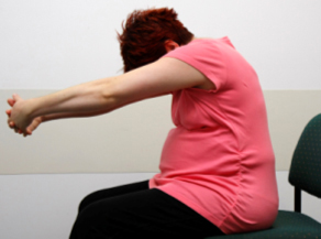 Pregnant lady stretching to prevent back ache